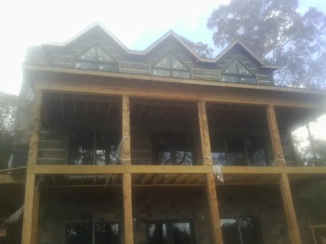 Dormers and porch framing on a large log home under construction — Roof Coating work by our crew in Payette