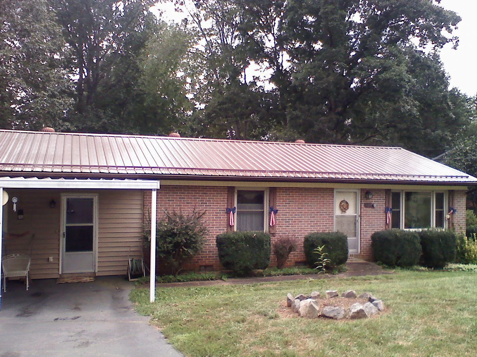 Bronze metal roof and carport on a brick ranch home — Roof Repair work by our crew in Payette
